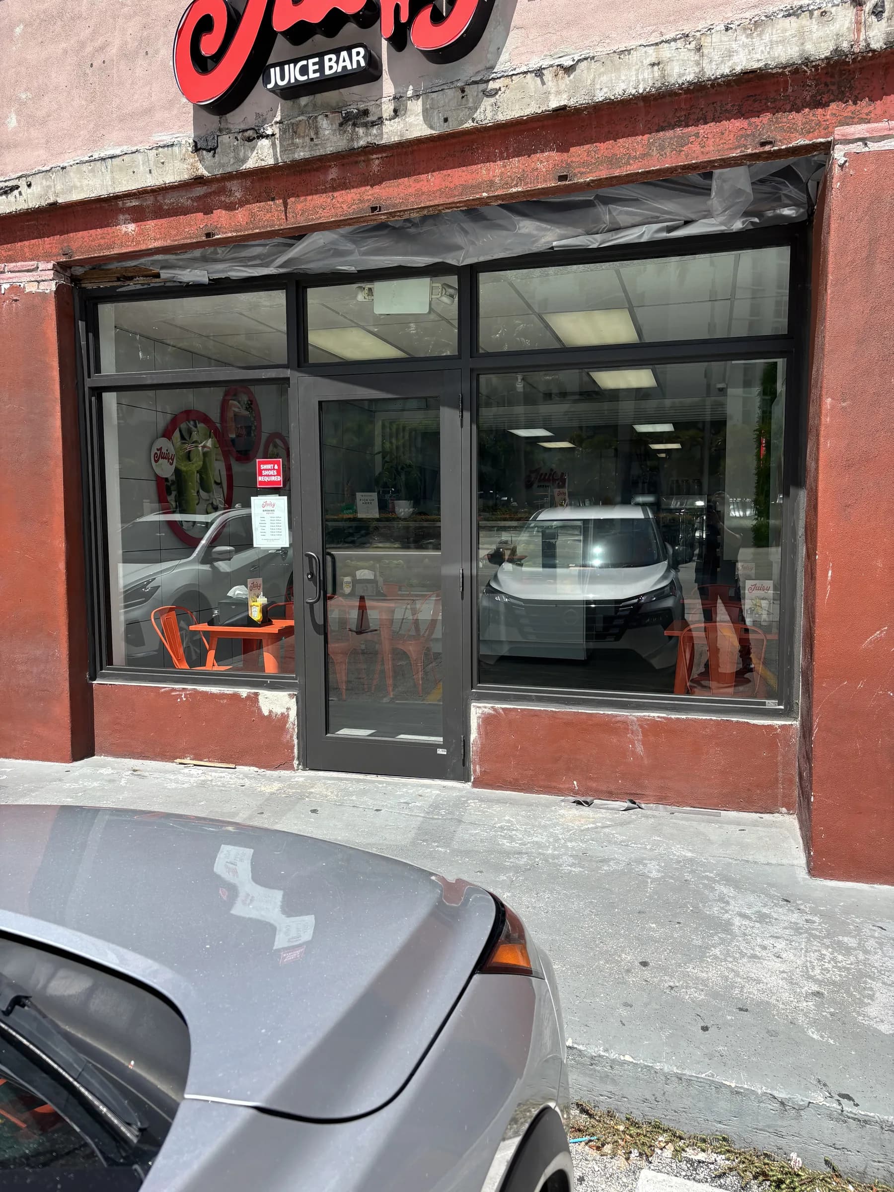 Dark bronze storefront glass entry door with sidelite and transom on a retail facade