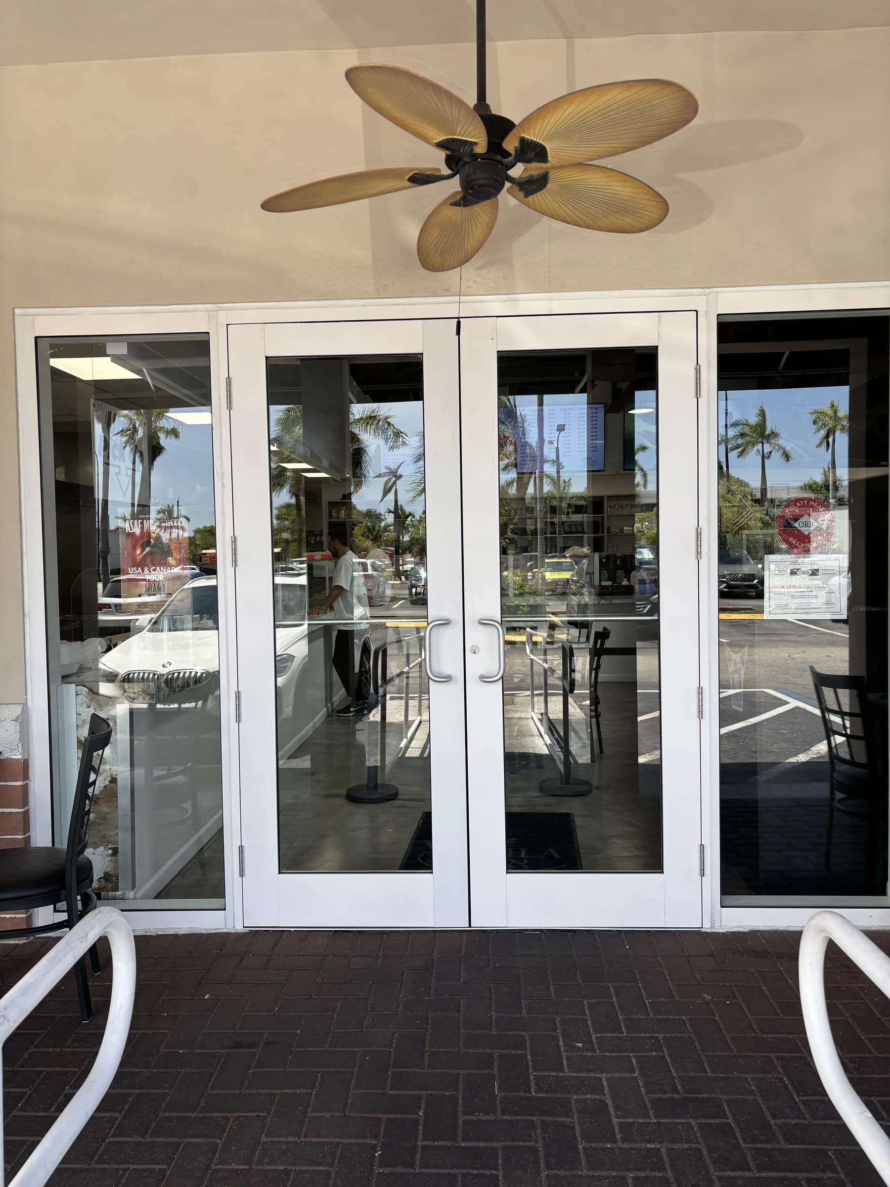 White aluminum storefront double glass doors with silver pull handles at a commercial entrance