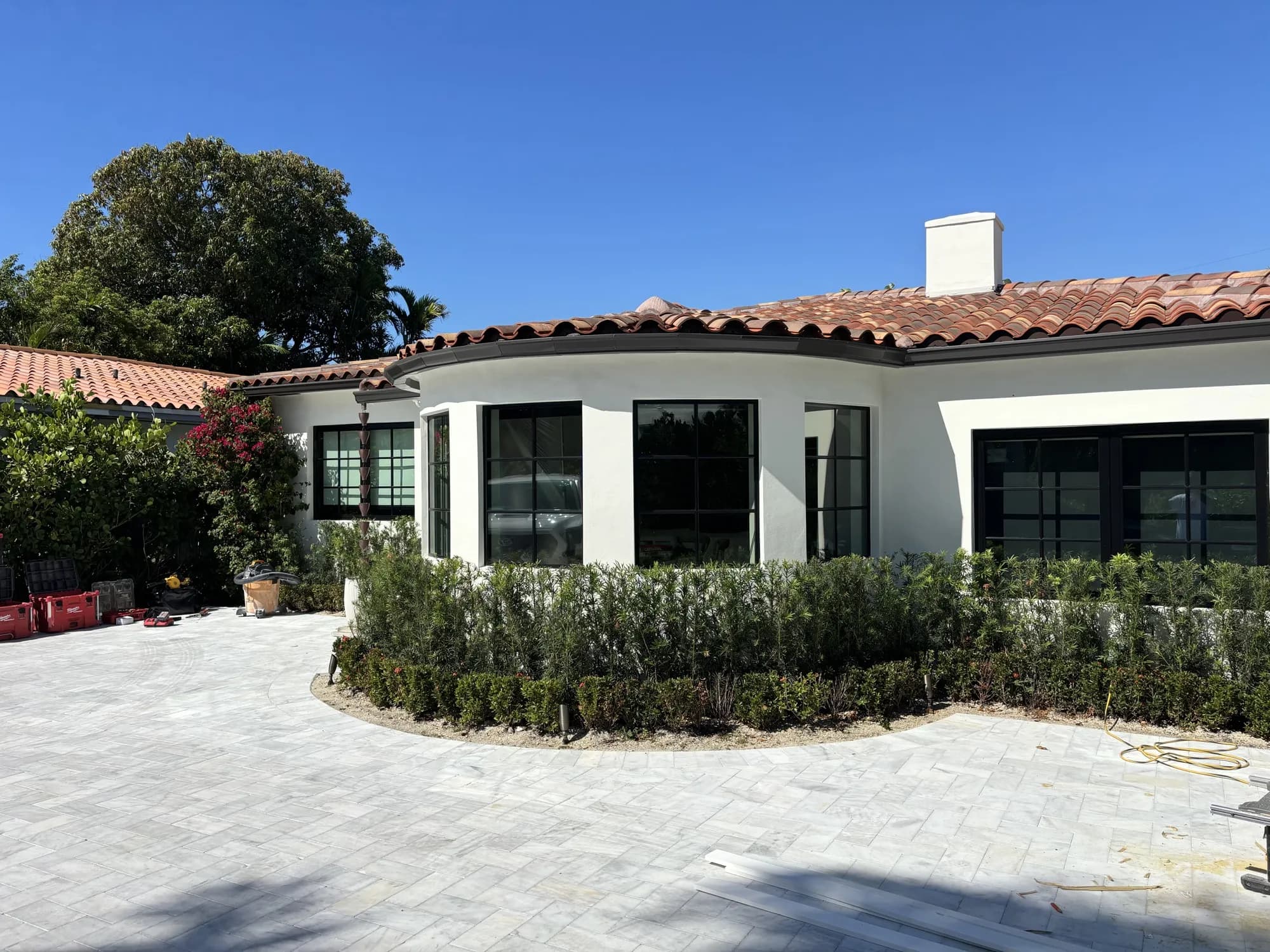 Mediterranean-style house with curved black-grid window wall and tile roof