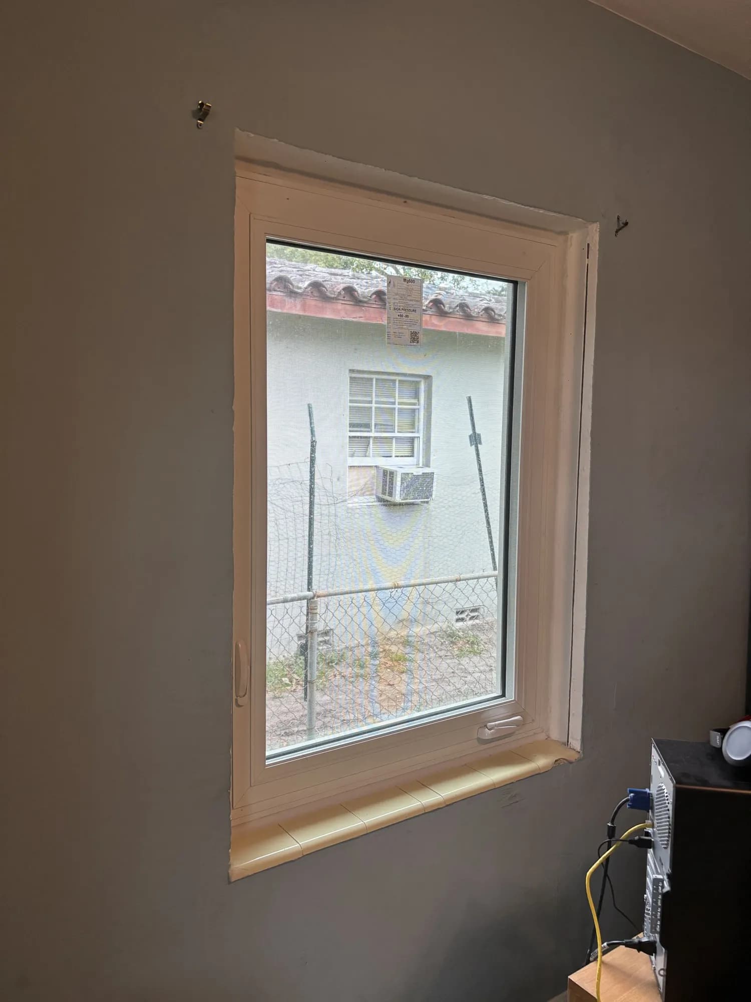 White casement window with crank handle and tiled sill in a finished room